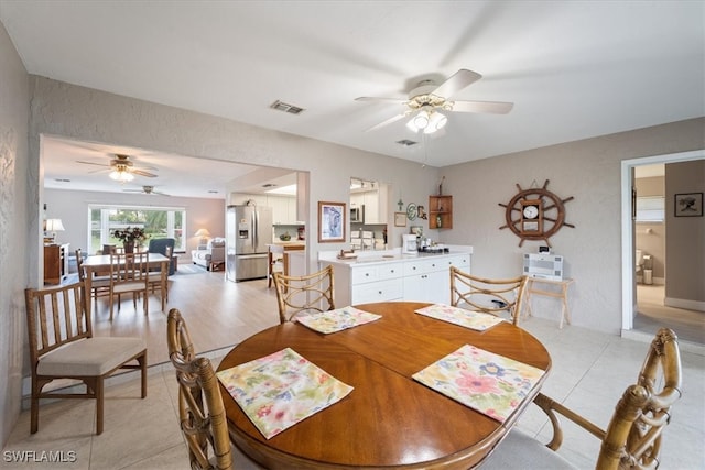 dining space featuring ceiling fan, light tile patterned floors, and sink