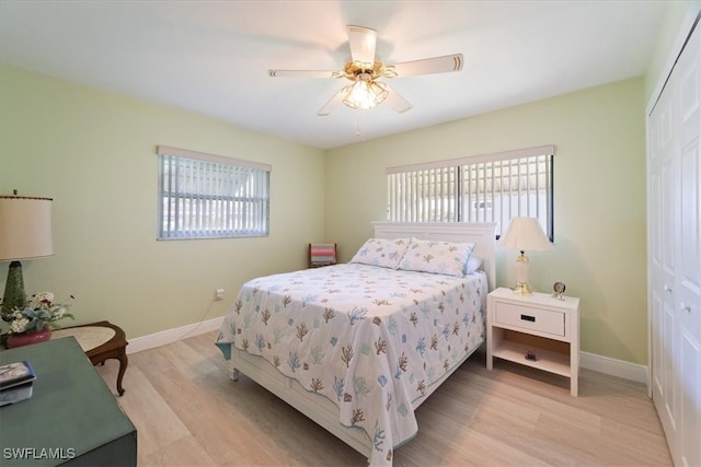 bedroom featuring light hardwood / wood-style floors, ceiling fan, and a closet