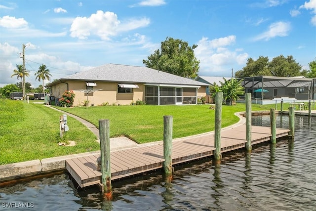 view of dock with a lawn and a water view