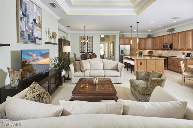 tiled living room featuring sink, a notable chandelier, ornamental molding, and a tray ceiling