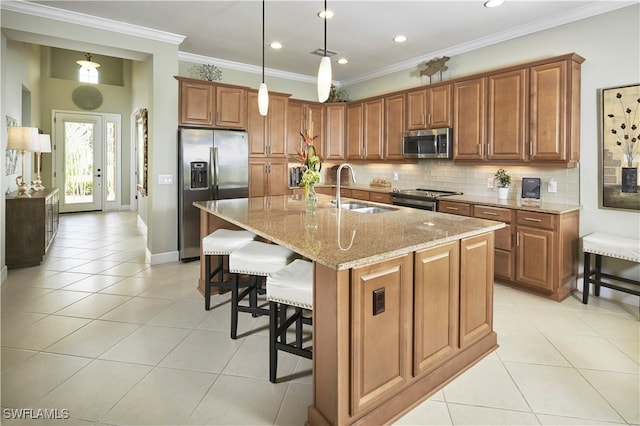 kitchen featuring crown molding, a center island with sink, stainless steel appliances, and sink