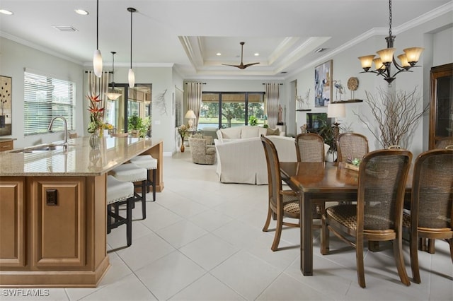 dining space with sink, crown molding, a notable chandelier, and a raised ceiling