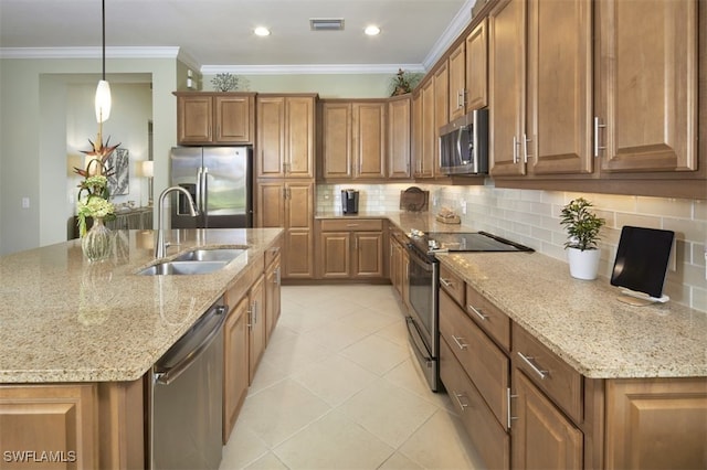 kitchen with light stone countertops, appliances with stainless steel finishes, sink, decorative light fixtures, and crown molding