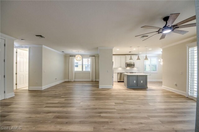 unfurnished living room featuring crown molding, ceiling fan, and light hardwood / wood-style flooring