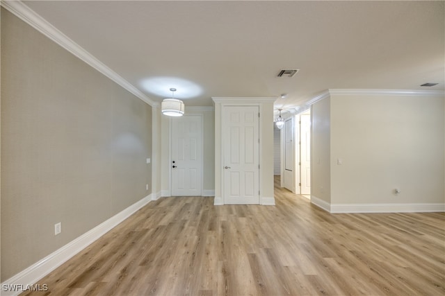 spare room featuring light wood-type flooring and ornamental molding