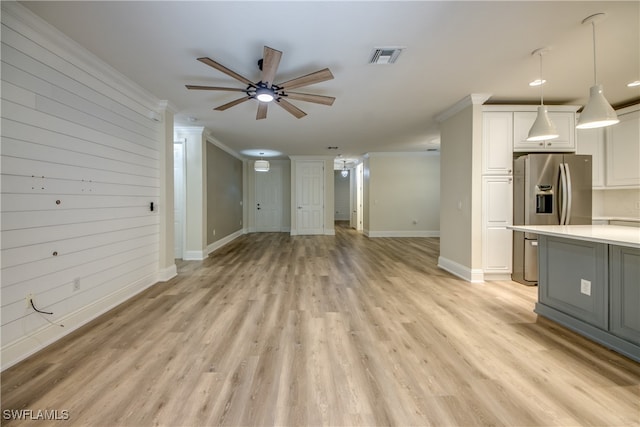 unfurnished living room featuring ceiling fan, light wood-type flooring, and ornamental molding