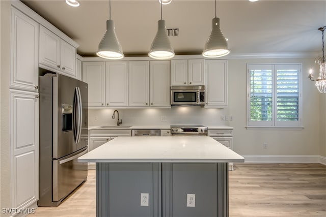 kitchen featuring pendant lighting, sink, light hardwood / wood-style flooring, a chandelier, and appliances with stainless steel finishes