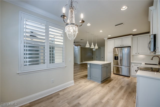 kitchen with white cabinets, stainless steel appliances, a chandelier, and a center island