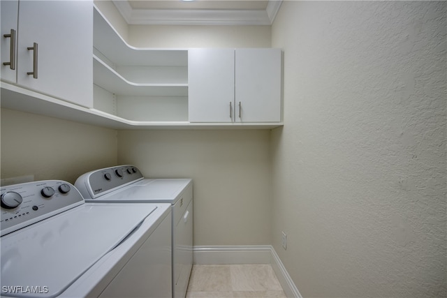 laundry room with cabinets, light tile patterned flooring, and washing machine and dryer