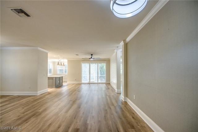 unfurnished living room with ceiling fan with notable chandelier, ornamental molding, and wood-type flooring