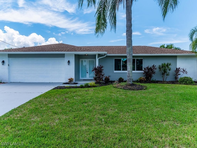 ranch-style home featuring a garage and a front lawn