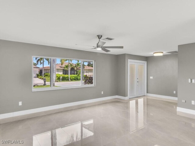 empty room featuring ceiling fan and light tile patterned floors