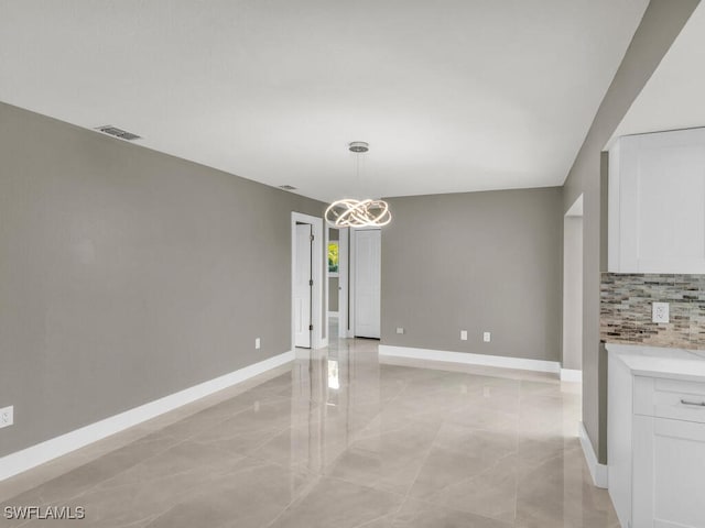 unfurnished dining area featuring a chandelier