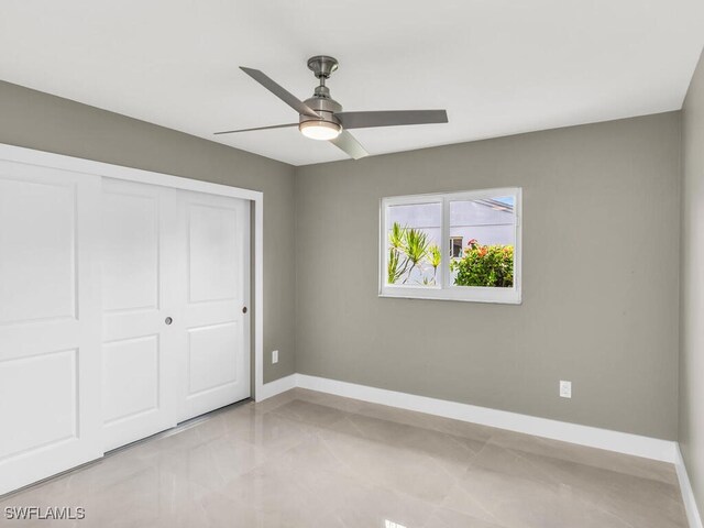 unfurnished bedroom featuring ceiling fan and a closet