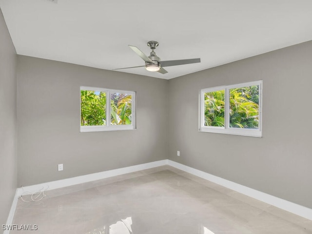 spare room featuring ceiling fan and a wealth of natural light