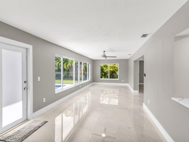 tiled spare room featuring ceiling fan