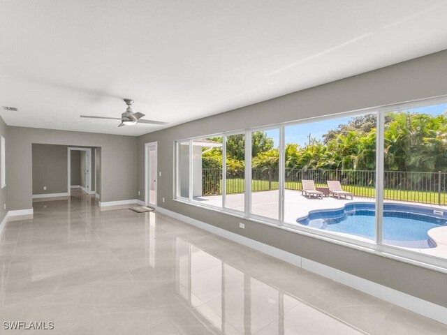 empty room with light tile patterned floors and ceiling fan