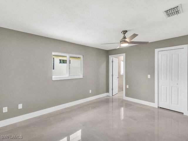 unfurnished bedroom with ceiling fan and a closet