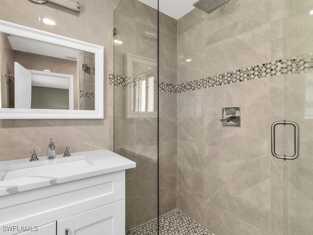 bathroom with a shower with shower door, sink, tile walls, and backsplash