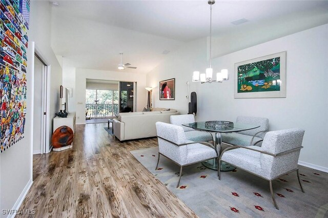 14850 Crystal Cove Ct Unit 402, Fort Myers, FL 33919 - dining area with high vaulted ceiling, baseboards, wood finished floors, and ceiling fan with notable chandelier