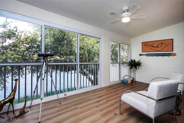 sunroom / solarium featuring lofted ceiling, plenty of natural light, and ceiling fan