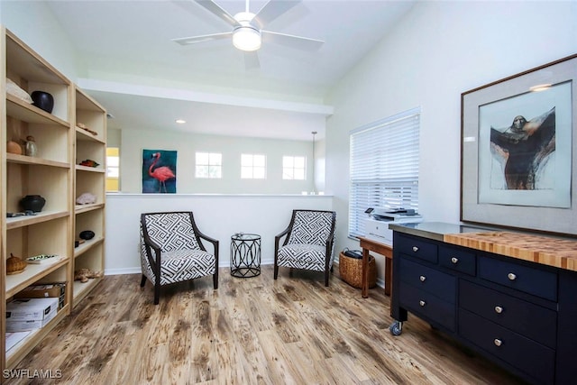 living area featuring light wood-type flooring and ceiling fan