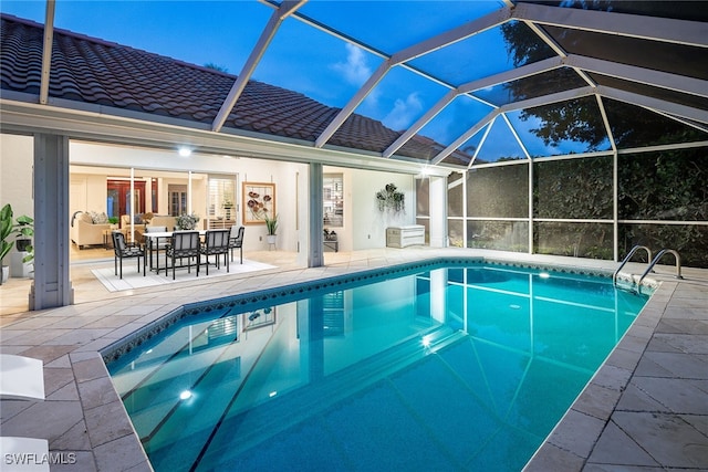 view of swimming pool featuring a patio and a lanai