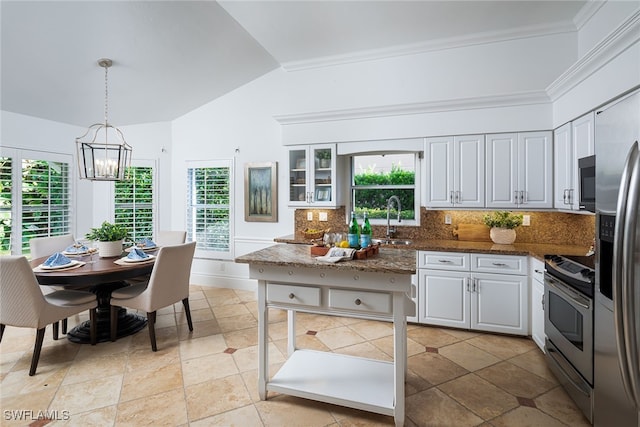 kitchen featuring sink, white cabinets, decorative backsplash, stainless steel appliances, and decorative light fixtures