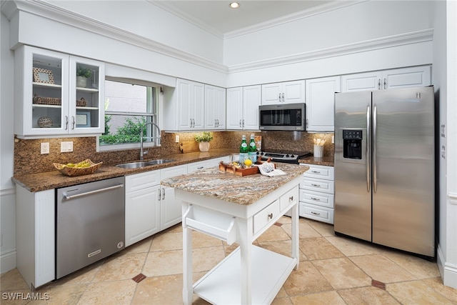 kitchen with dark stone counters, stainless steel appliances, white cabinets, and decorative backsplash