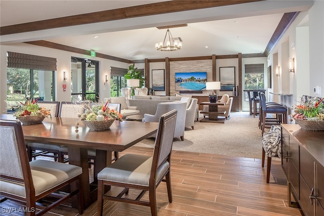 dining space featuring a notable chandelier, light hardwood / wood-style flooring, ornamental molding, and a healthy amount of sunlight