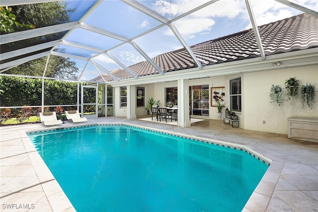 view of pool featuring glass enclosure and a patio