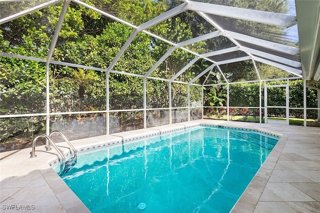 view of pool featuring glass enclosure and a patio area