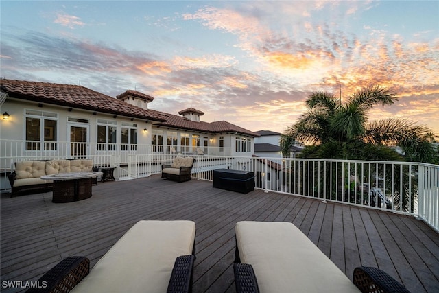 deck at dusk featuring an outdoor living space