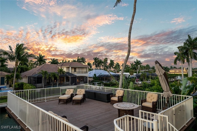 deck at dusk with an outdoor living space with a fire pit