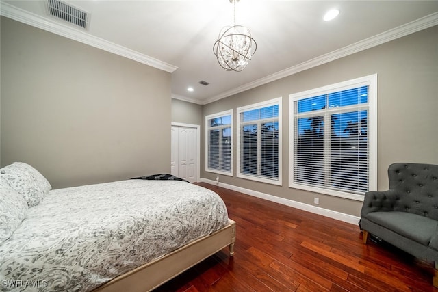 bedroom with a notable chandelier, dark hardwood / wood-style floors, ornamental molding, and a closet