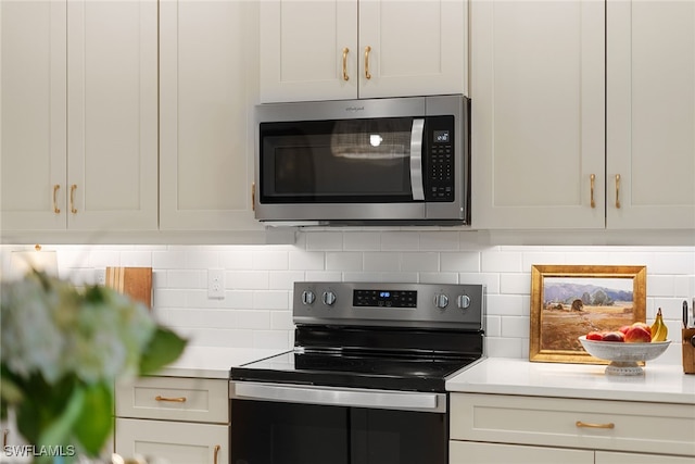 kitchen featuring backsplash, white cabinetry, and stainless steel appliances