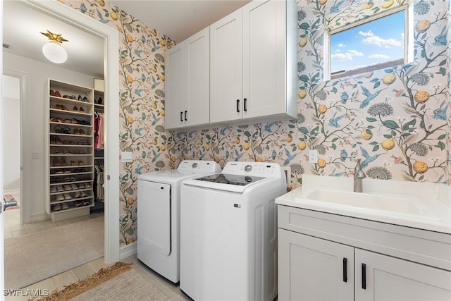 washroom with cabinets, sink, and washing machine and clothes dryer