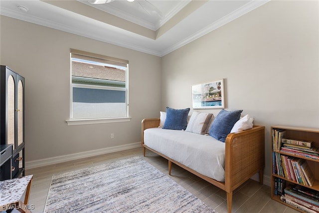 sitting room featuring a tray ceiling, crown molding, and light wood-type flooring