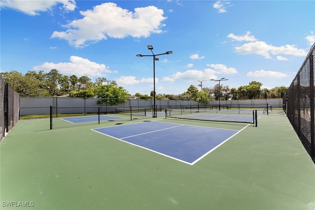 view of tennis court with basketball hoop