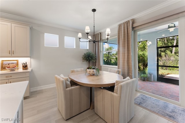 dining space with ceiling fan with notable chandelier, light wood-type flooring, and crown molding