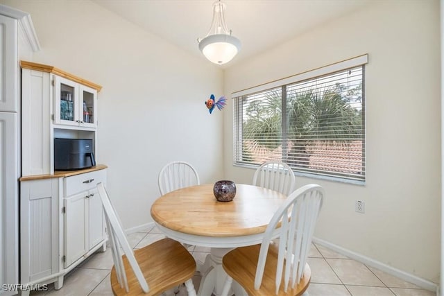 dining space featuring light tile patterned floors and baseboards