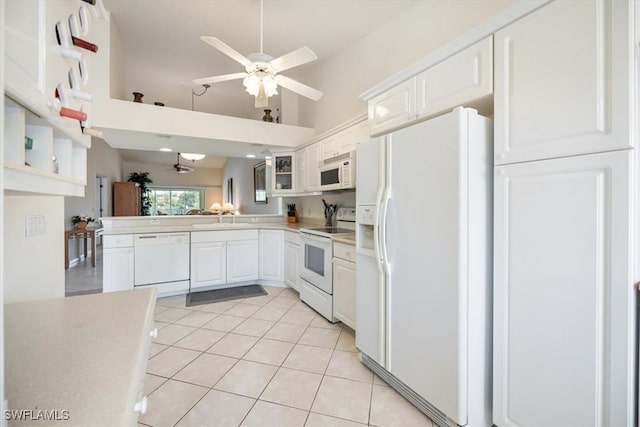 kitchen with white appliances, light tile patterned floors, a ceiling fan, white cabinetry, and a sink