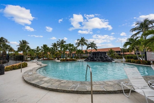 pool with a patio area and fence