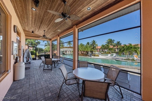 sunroom / solarium with wood ceiling and ceiling fan