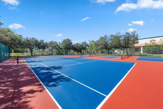 view of tennis court featuring community basketball court and fence