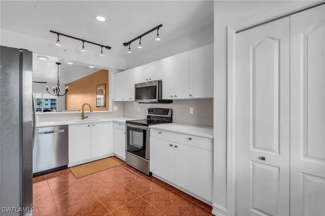 kitchen with pendant lighting, stainless steel appliances, backsplash, and white cabinets