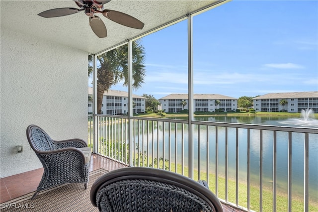 sunroom with a water view and ceiling fan