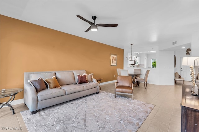 tiled living room featuring ceiling fan with notable chandelier