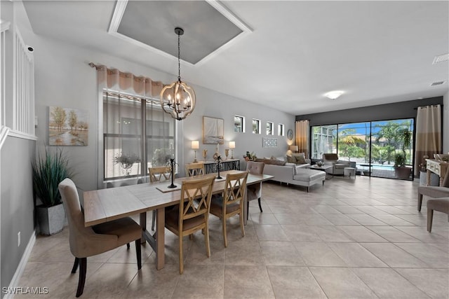 dining room with light tile patterned floors, an inviting chandelier, and a raised ceiling