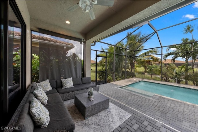 view of pool featuring an outdoor hangout area, glass enclosure, ceiling fan, and a patio area